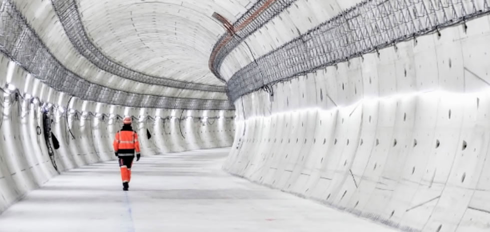 Hombre ropa de seguridad de alta visibilidad caminando por un túnel blanco