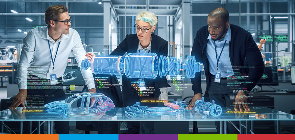 Three people looking at a 3D model of an electric engine standing over a desk