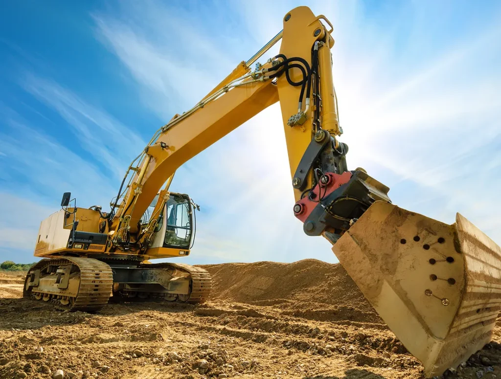 Machine working over the soil making it place yellowish shades with blue sky showing white overlay of clouds